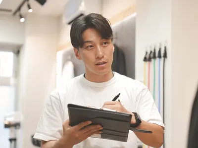 タブレットを手に、記録を見ながら話す赤澤優